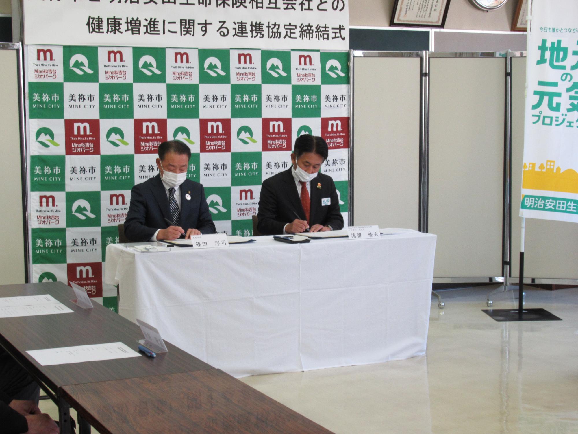 協定書に調印する徳留隆夫支社長（右）と篠田市長（左）