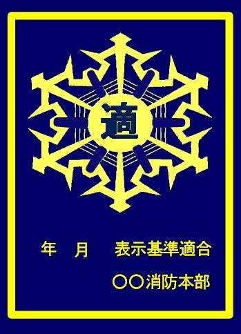 紺地に黄色で、中央に「適」と書かれた徽章のデザインと、「年月 表示基準適合 消防本部」と記載された防火対象物用の適合マーク