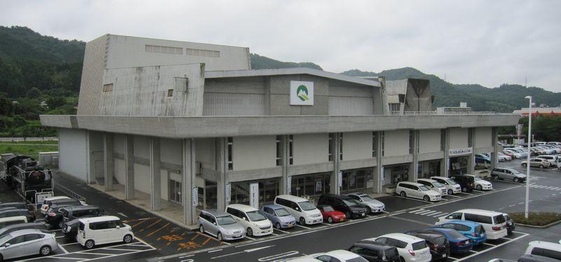 美祢市の支障が建物上部の壁にある美祢市民会館外観と広い駐車場の写真