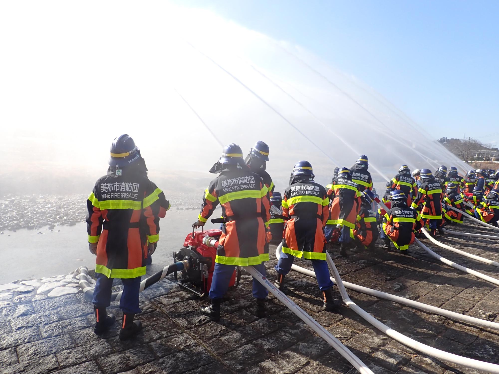 一斉放水をする消防団員