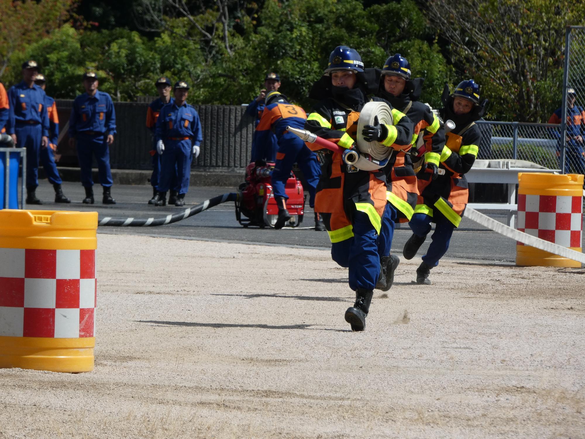 ホースを延長する消防団員