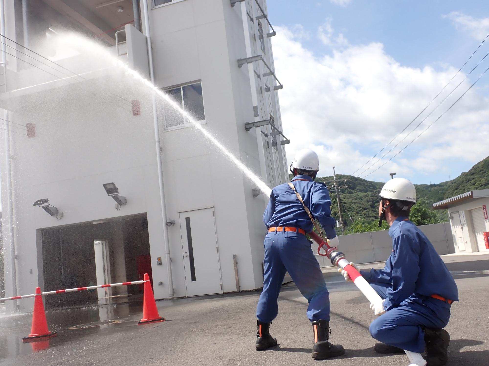 訓練塔2階へ放水する消防団員