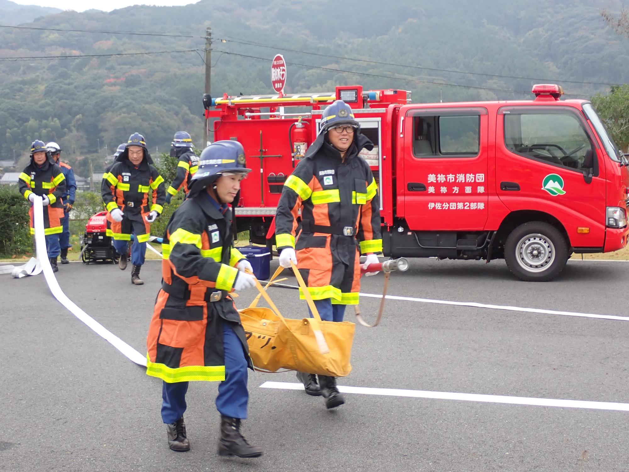 ホースを延長する消防団員