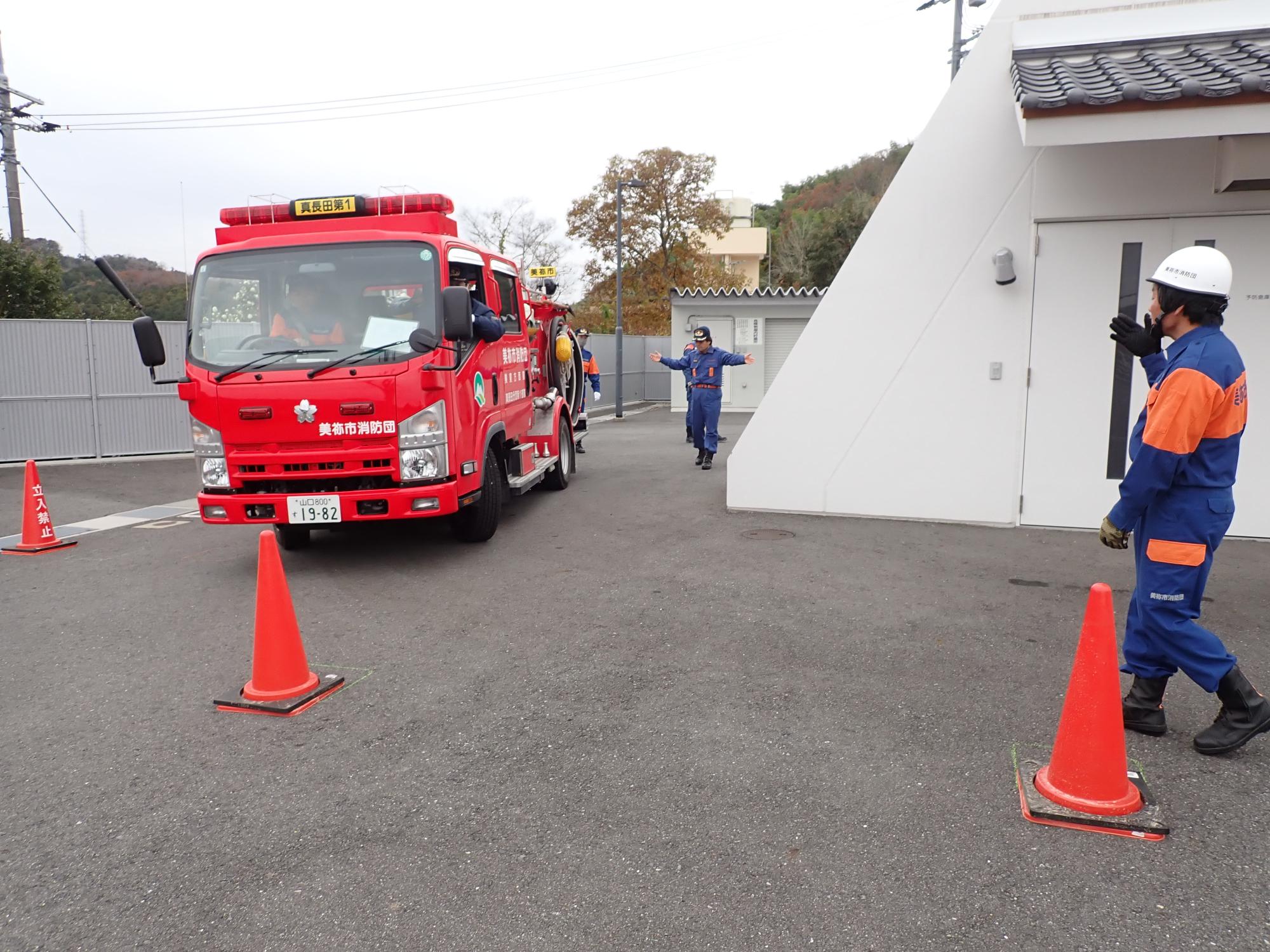 消防車両を誘導する消防団員