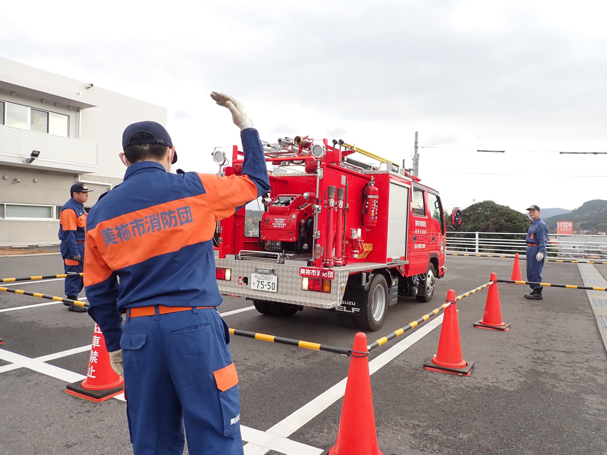 消防車両を誘導する消防団員