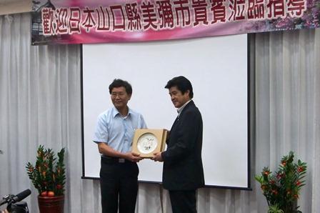 贈呈品を持った村田弘司 美祢市長と江龍漢 水里郷長の記念写真
