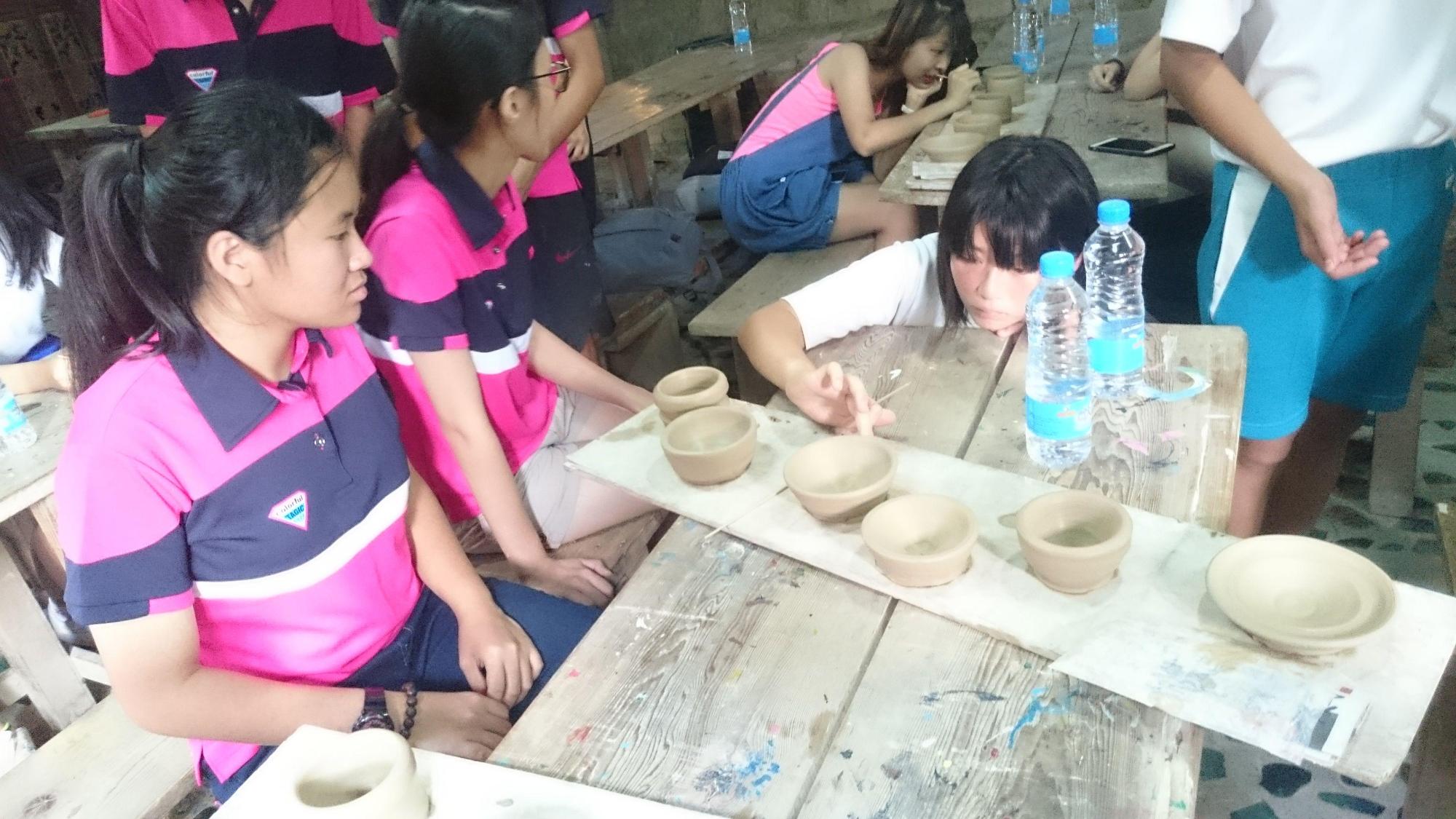 女子生徒達が陶器を作ってテーブルに並べている写真