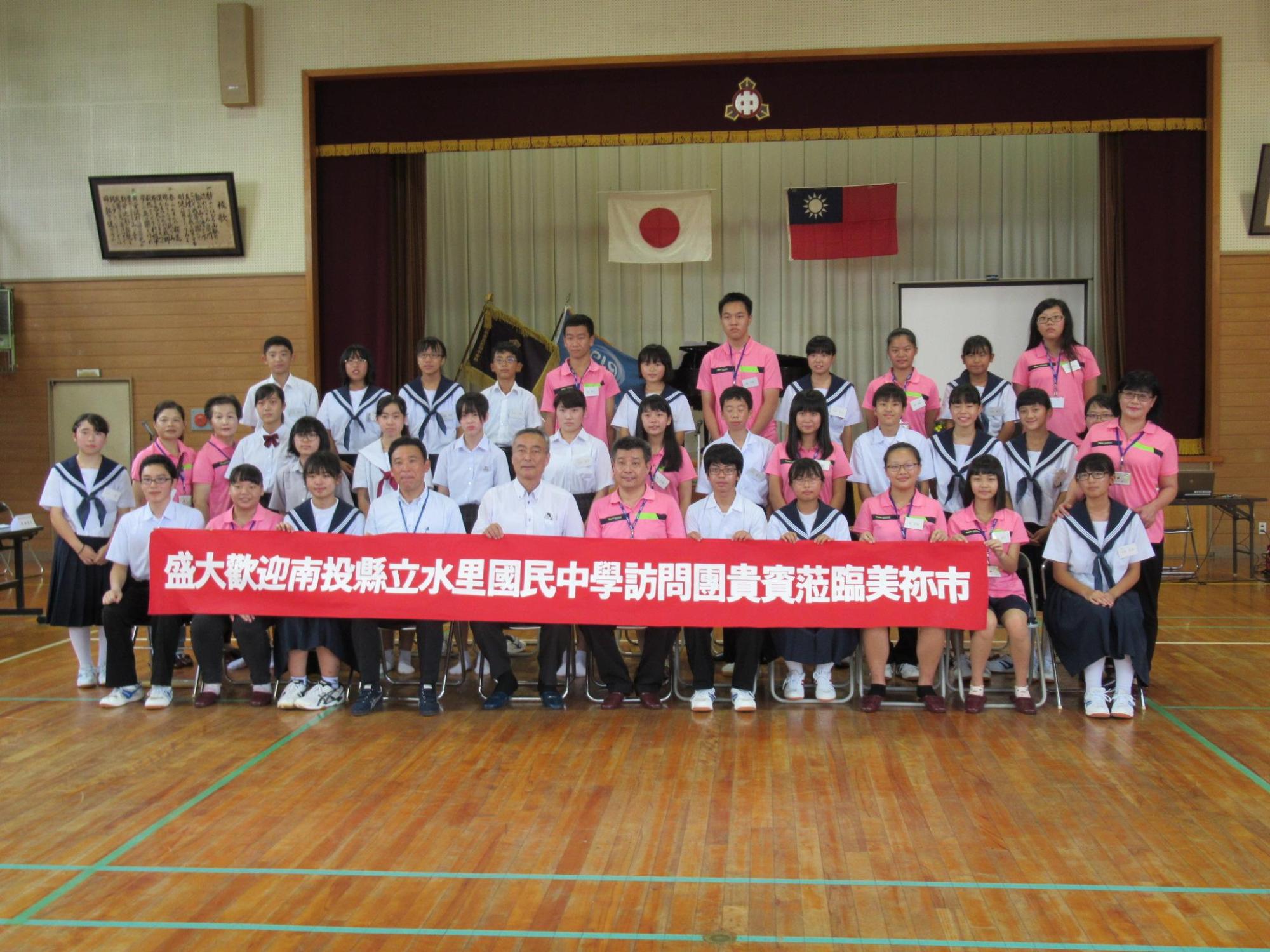 横断幕を持った美祢市の中高生と台湾南投縣水里郷の水里国民中学の生徒たちの集合写真