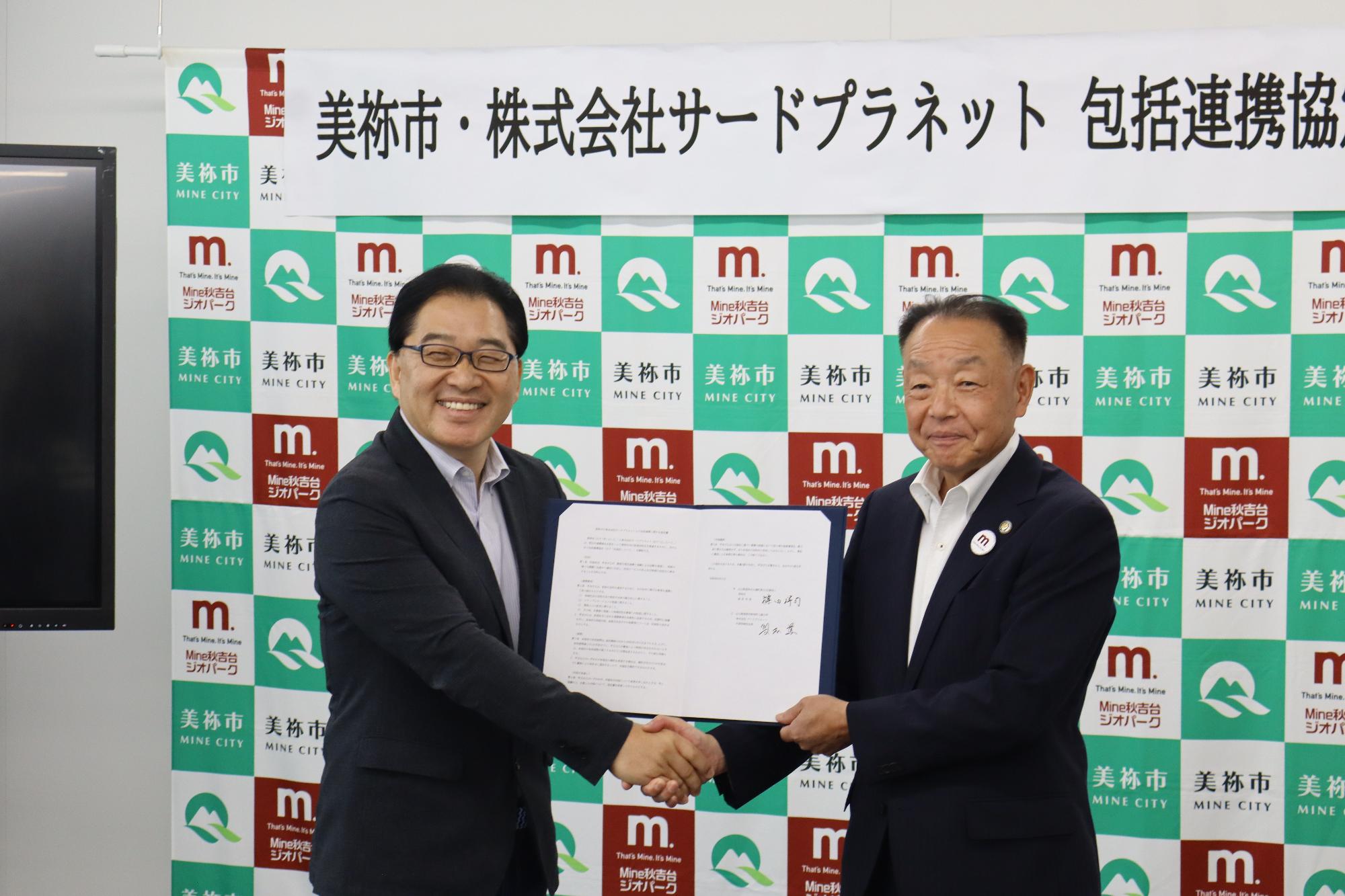 協定締結時握手を交わす市長と児玉会長